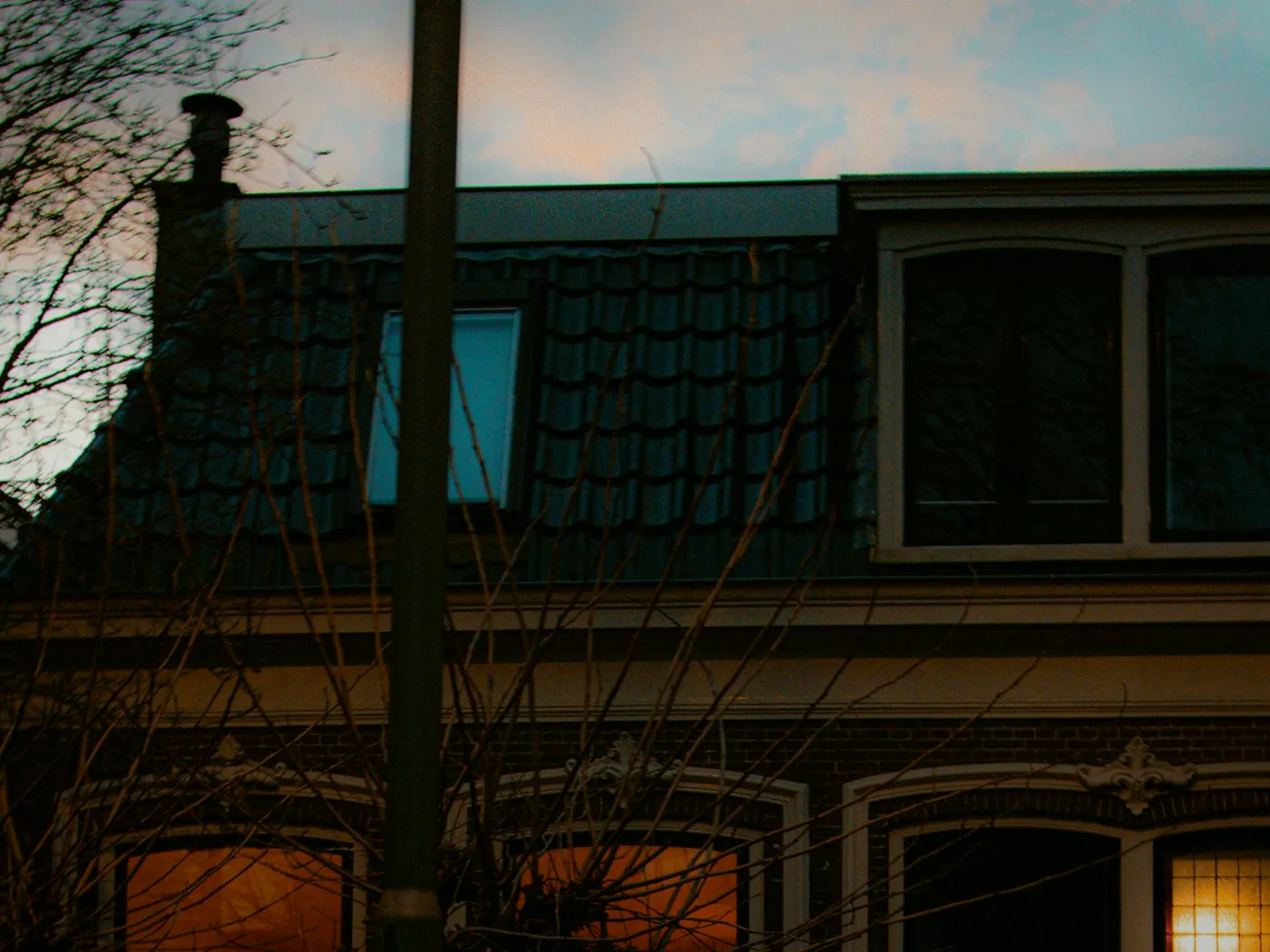 Coral Ridges' Cunningham Street frontage after dark, a single lamp lit above the old ticket window.