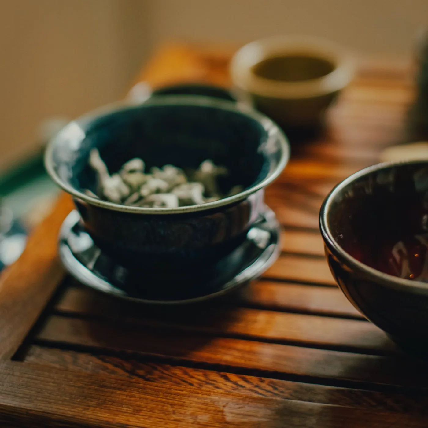 A mug of tea set down next to a scorepad at a table mid-hand of crib.